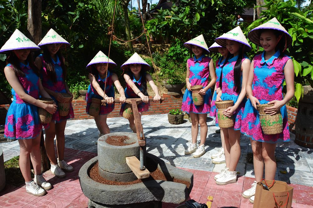 姑娘们用石磨研磨咖啡